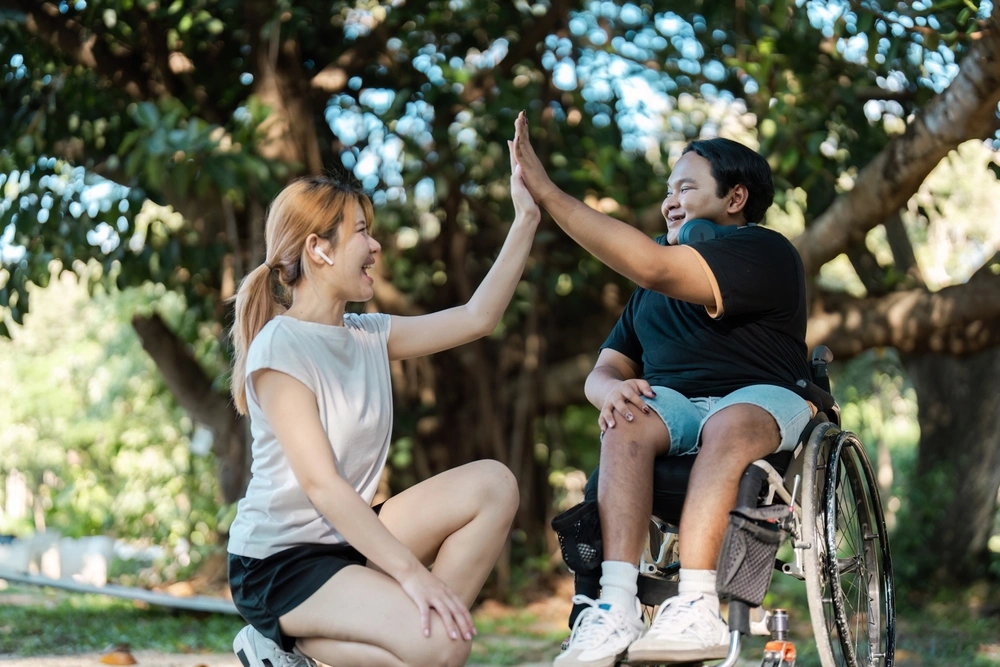 disabled women hanging out with care assistant in a park